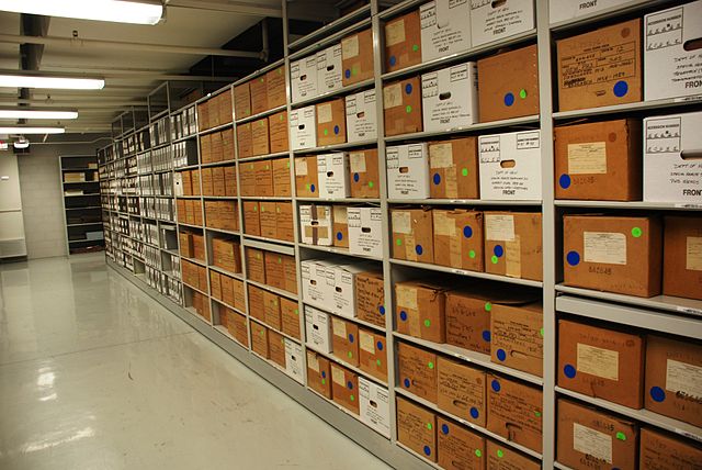 Rows of metal shelves with cardboard boxes.
